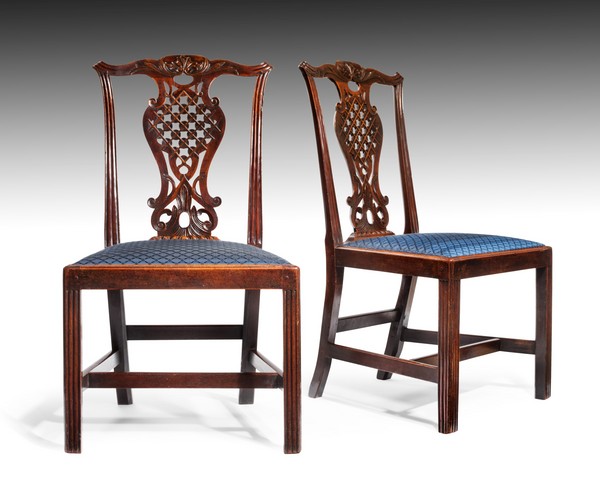 A rare and exquisitely carved pair of early George III period mahogany side chairs in the Chinese Chippendale manner